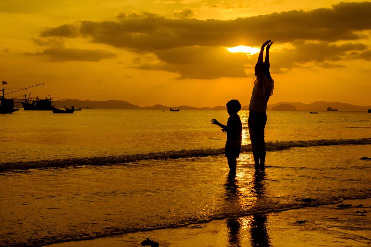 Keluarga berjalan santai menikmati sunset di Pantai Kuta Bali