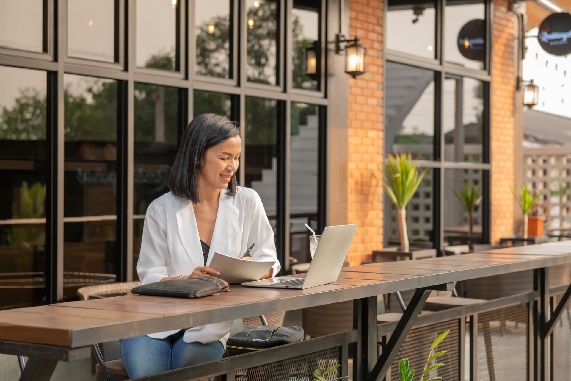 Profesional bekerja dengan laptop di kafe dengan pemandangan indah — konsep bleisure travel